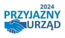 Logo Przyjazny Urząd 2024. Dwie ściśnięte na znak przyjaźni dłonie z tekstem Przyjazny Urząd 2024.